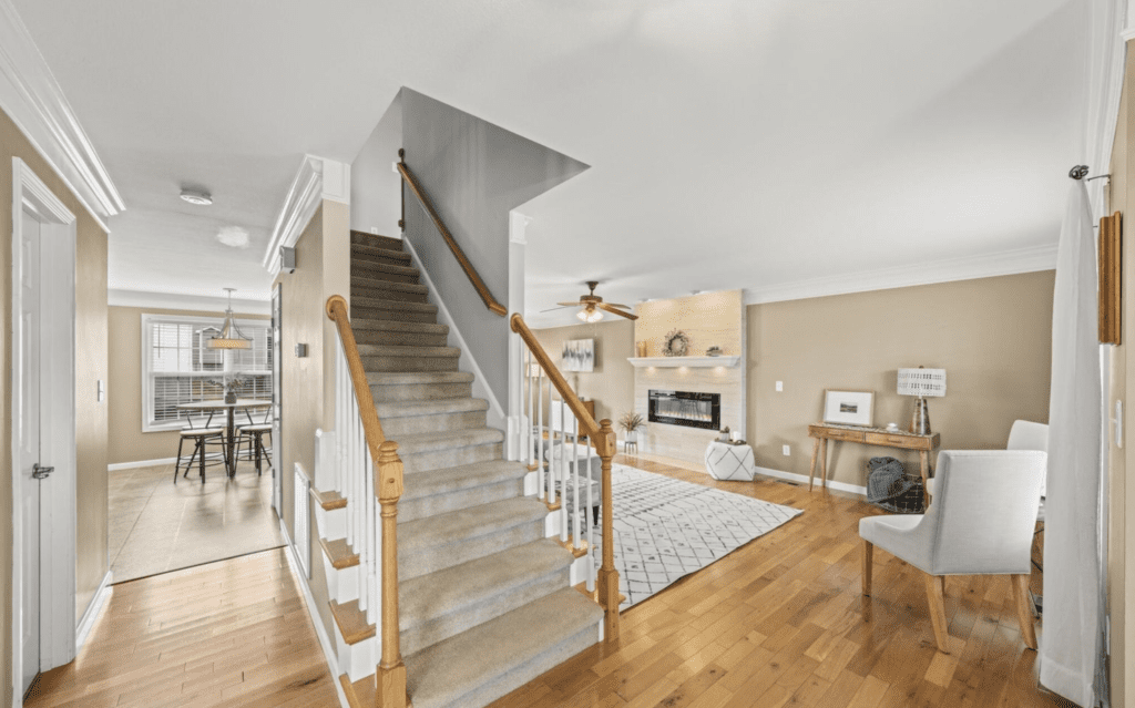 Bright, modern staircase in an open living space with wooden floors.