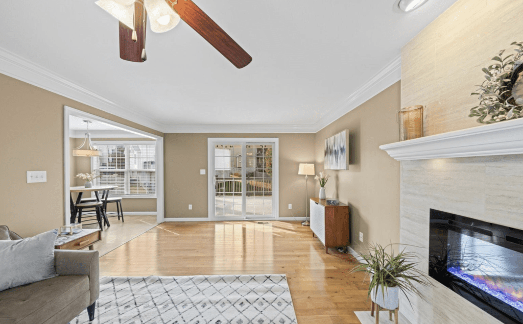 Bright living room with hardwood floors and ceiling fan.