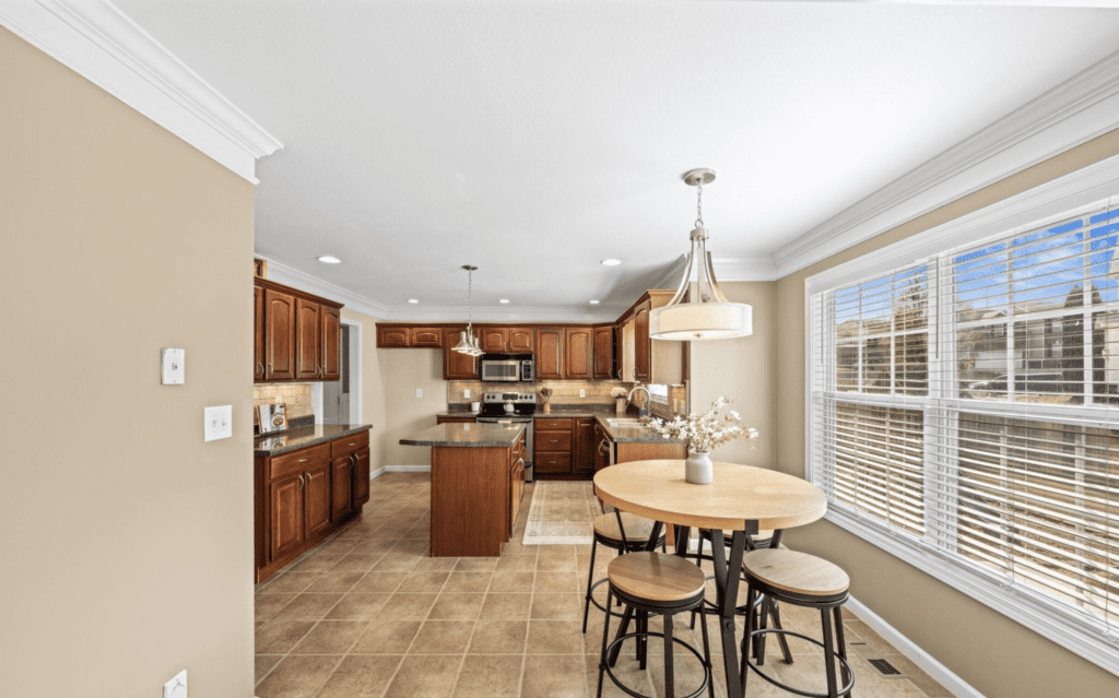 Bright kitchen with wooden cabinets and a dining area with round table.