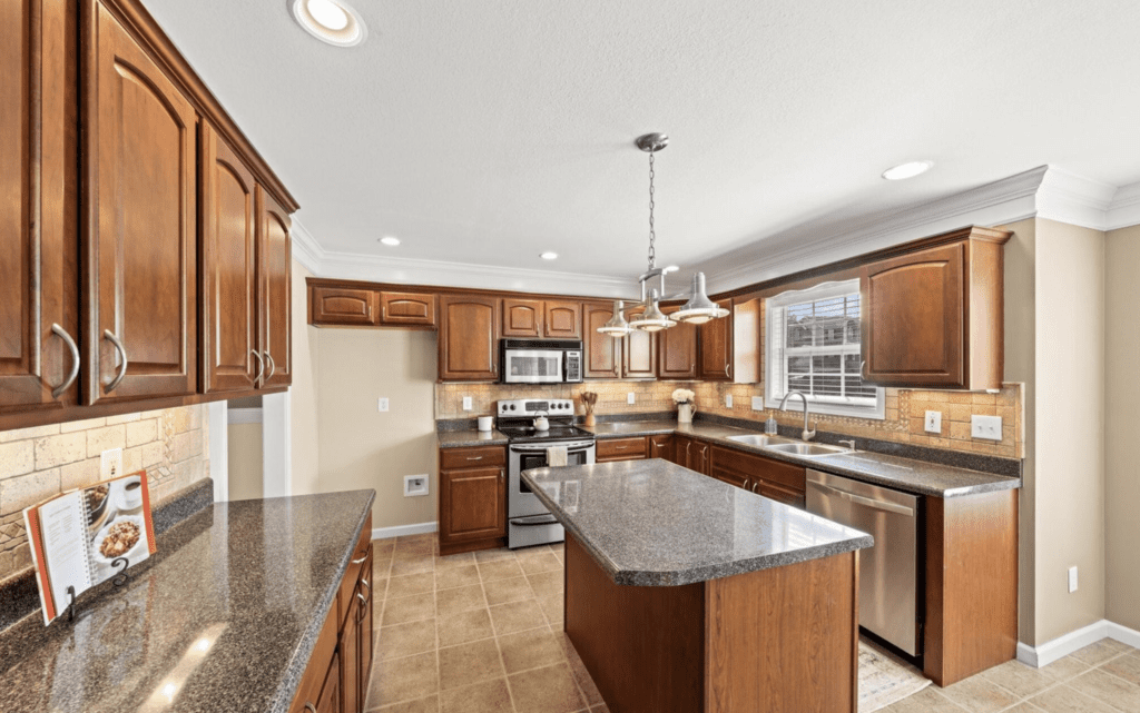 Modern kitchen with wooden cabinetry and granite island.