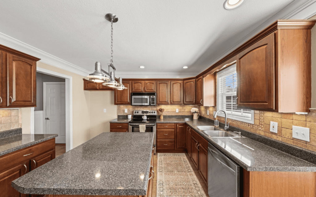 Spacious modern kitchen with wooden cabinets and granite countertops.