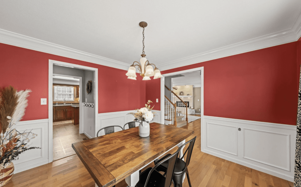 Cozy dining room with red walls and wooden table.