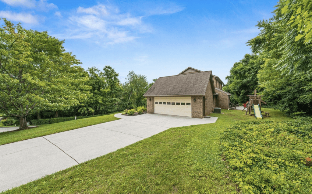 A modern house with a spacious driveway and lush green lawn.