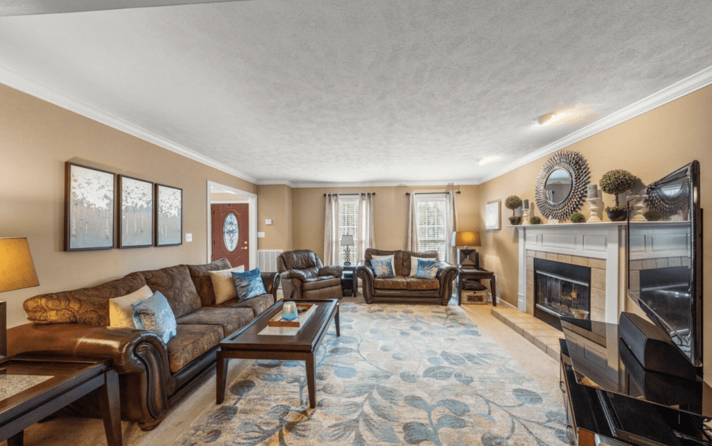 Cozy living room with brown leather sofas and a fireplace.