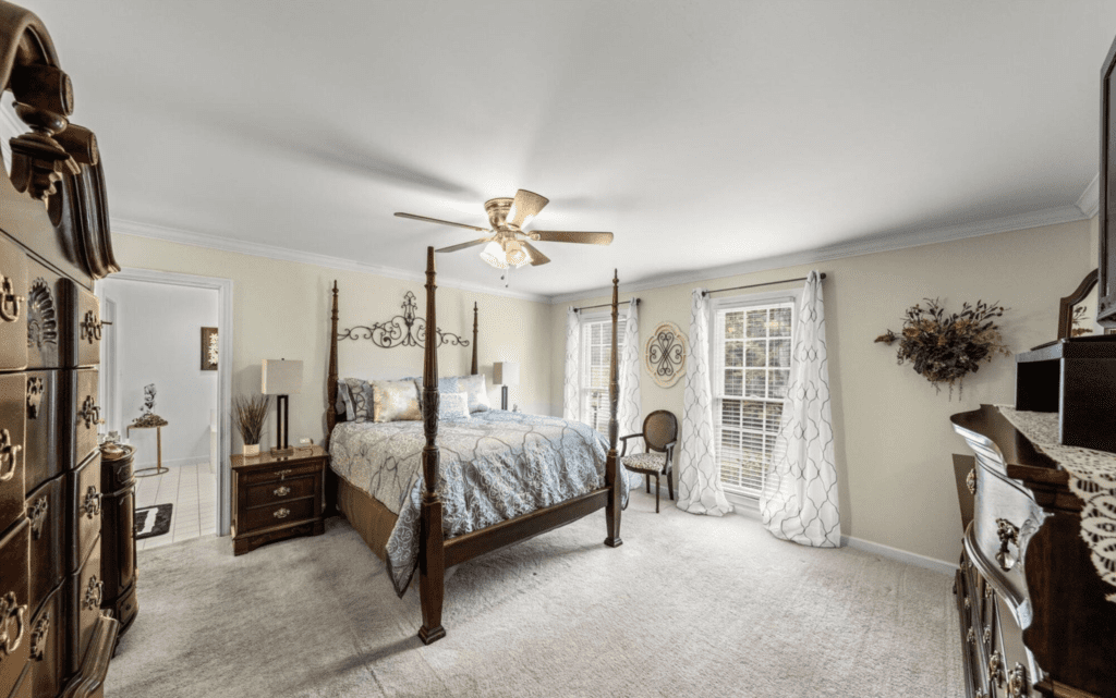 Bright bedroom with a four-poster bed and elegant decor.