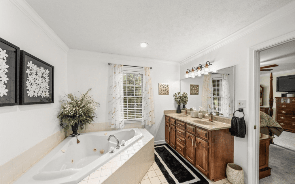 Elegant bathroom with a large bathtub and wooden vanity.