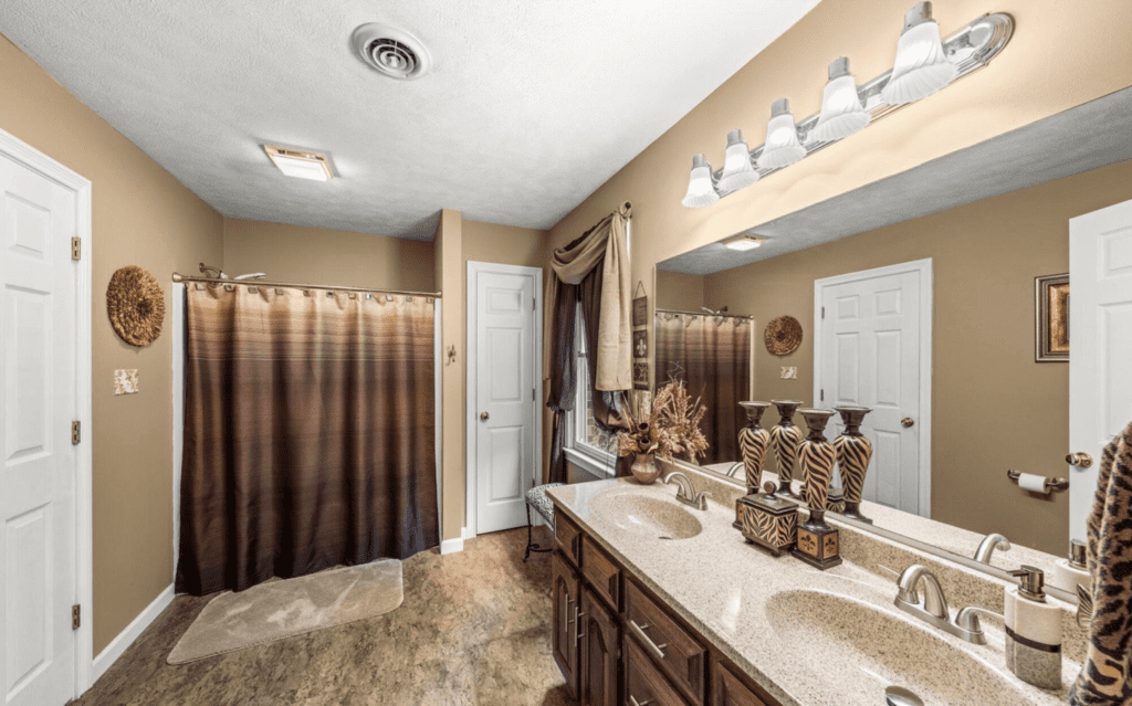 Spacious bathroom with dual sinks and a brown-themed shower curtain.