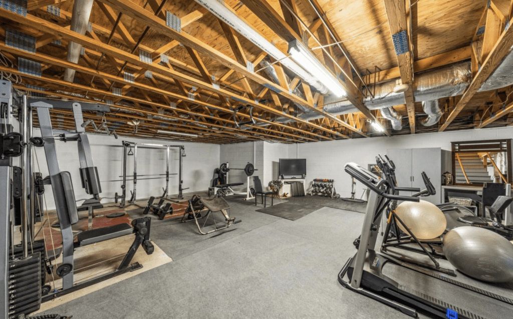Spacious home gym with wooden ceiling and various workout equipment.