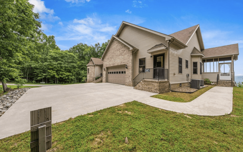 Modern suburban house with a spacious driveway and garage under a clear blue sky.