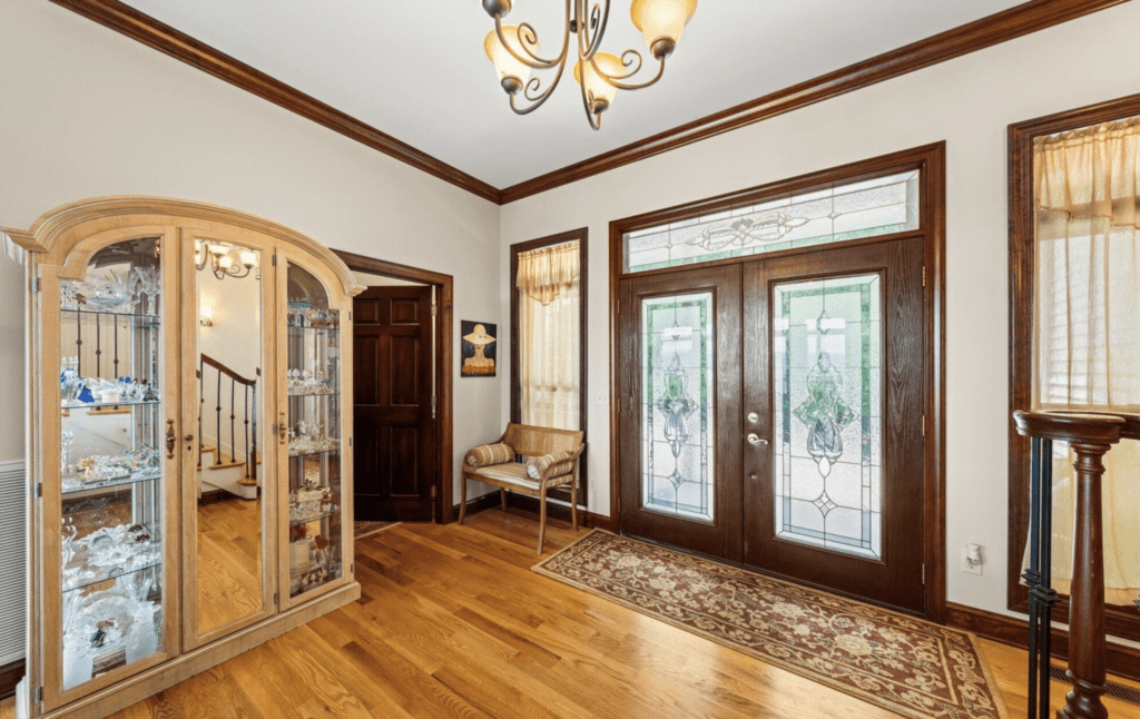 Elegant foyer with wooden floors and decorative glass doors.