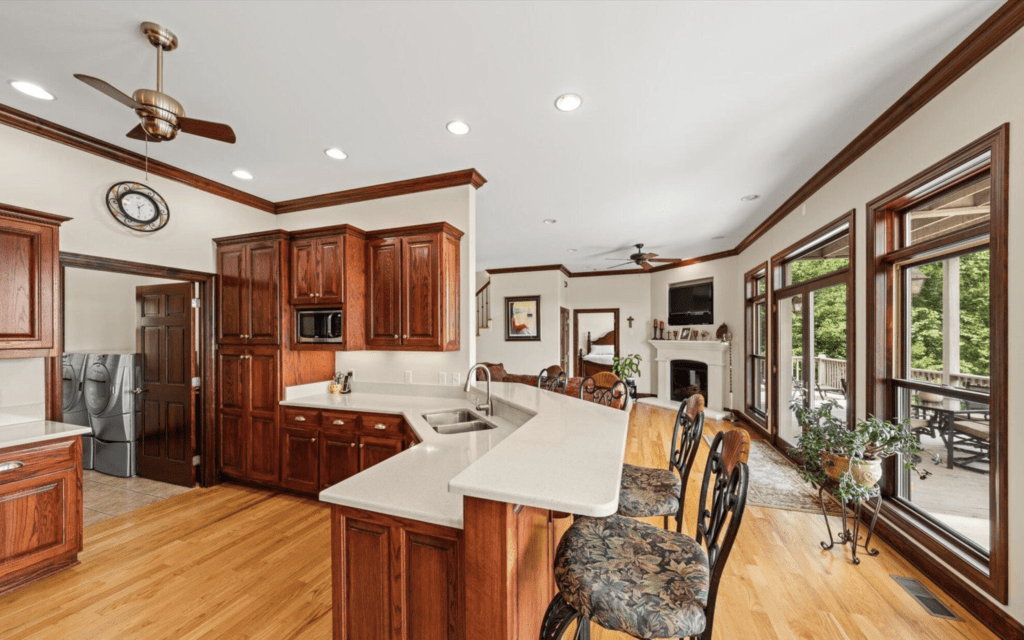 Spacious kitchen with wooden cabinetry and a breakfast bar overlooking the living room.