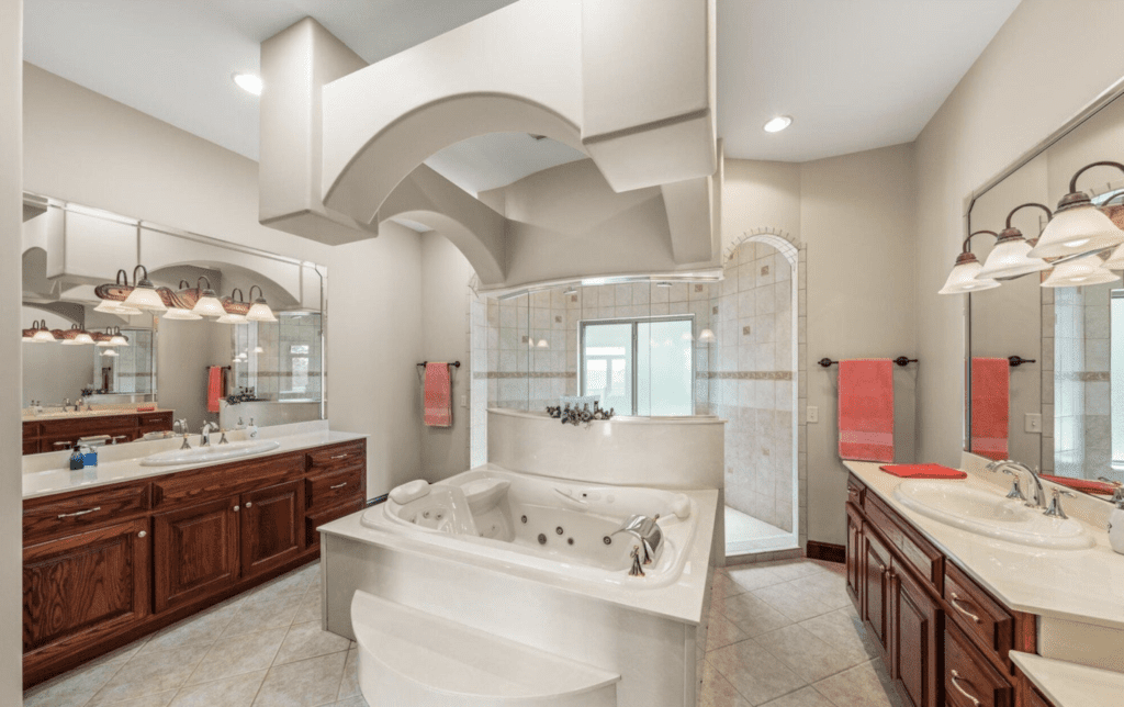 Luxurious bathroom with a large whirlpool tub and elegant wooden cabinetry.