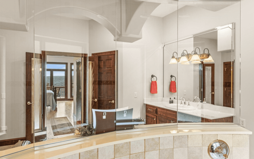 Luxurious bathroom with wooden accents and clear glass shower enclosure.