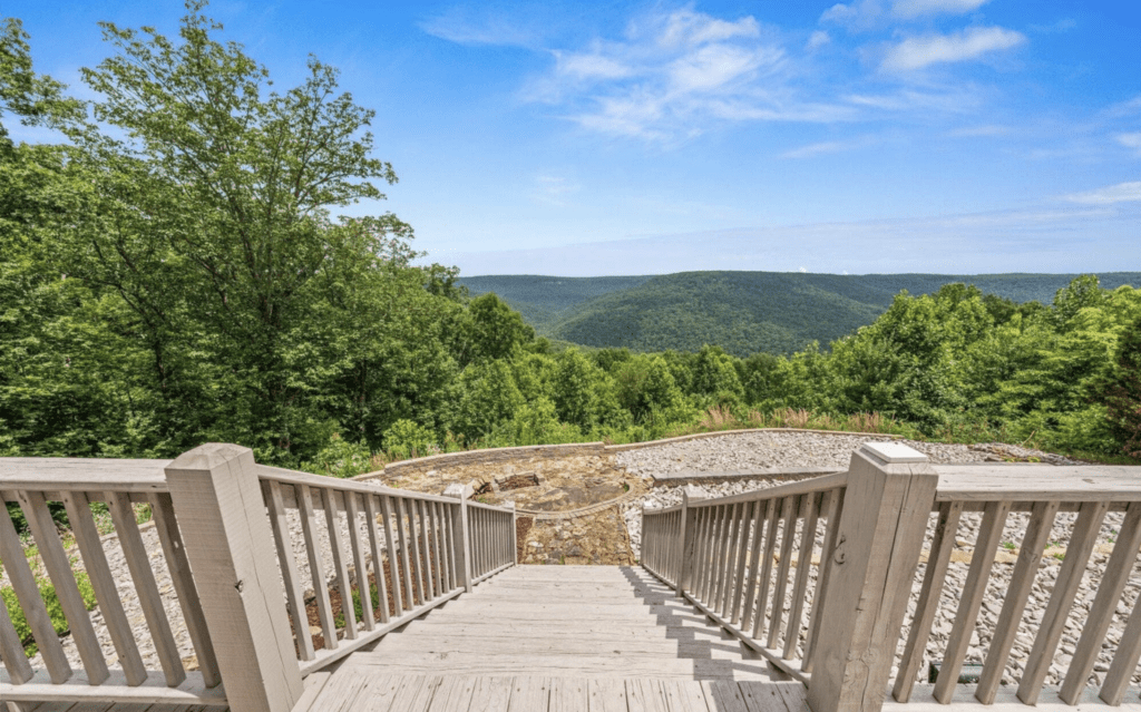 Wooden stairs leading down to a scenic overlook of lush green hills.