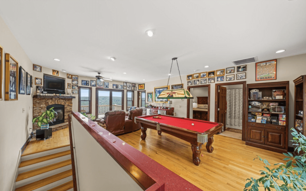 Spacious game room with a red pool table and comfortable seating.