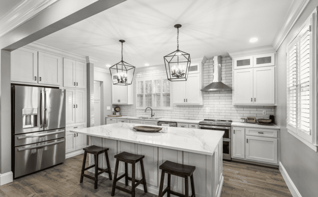 Bright modern kitchen with white cabinetry and island seating.