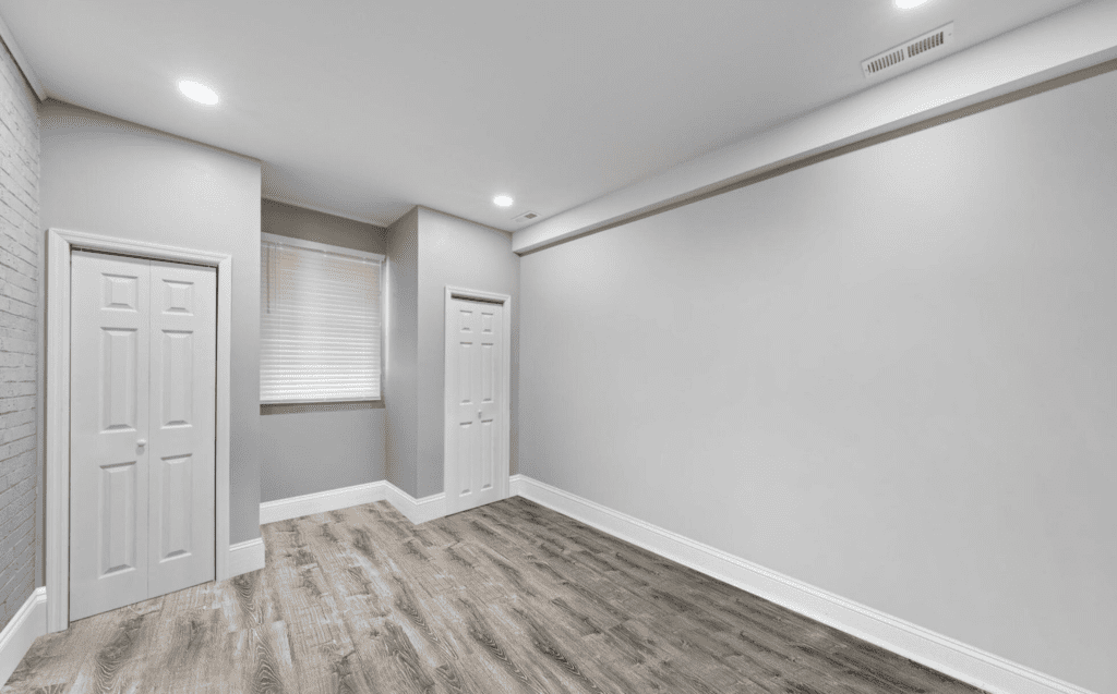 Empty room with wood flooring and white walls.