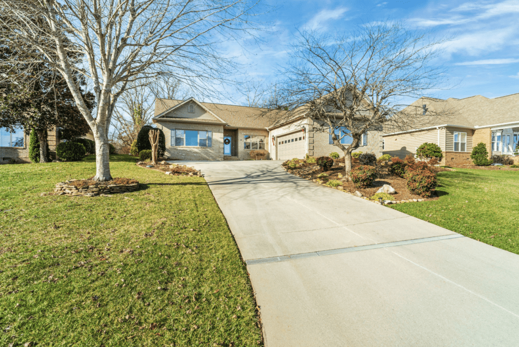 Spacious driveway leading to a suburban house with a well-kept lawn.
