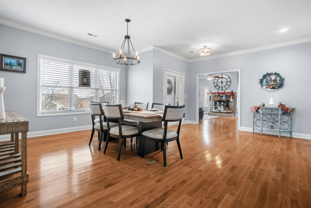 Bright dining room with wooden floor and modern chandelier.