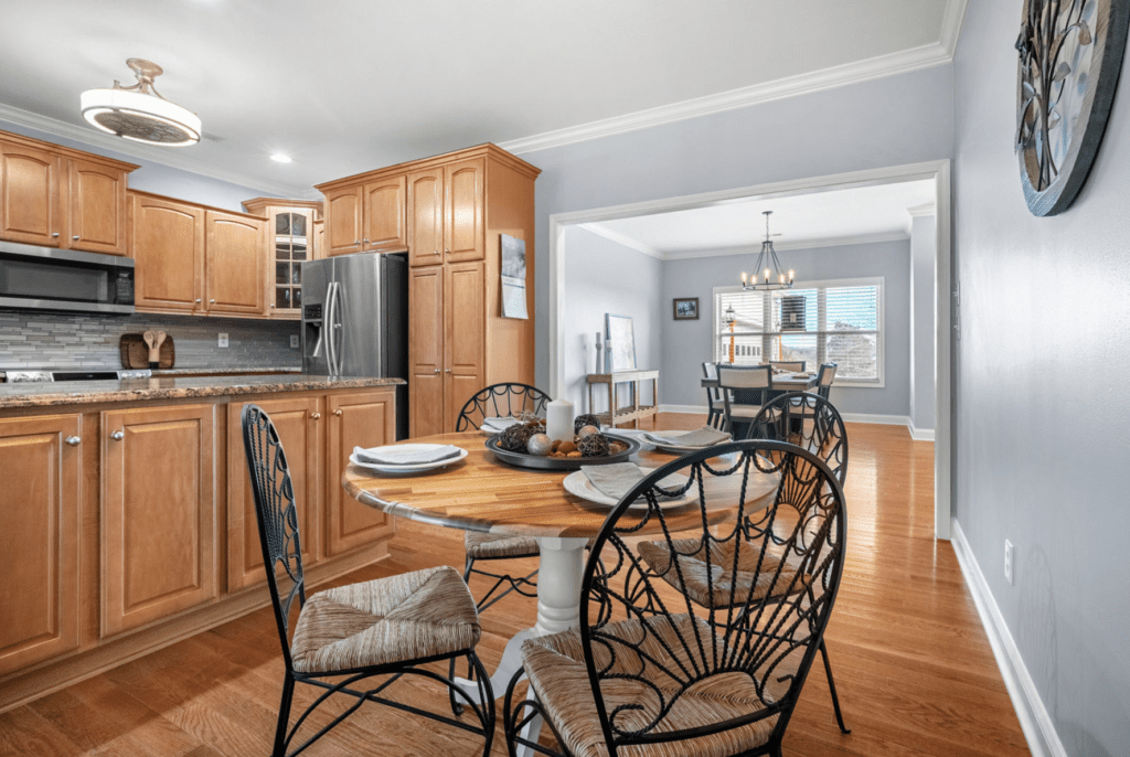 Cozy dining area with a round wooden table and wrought iron chairs in a modern kitchen.