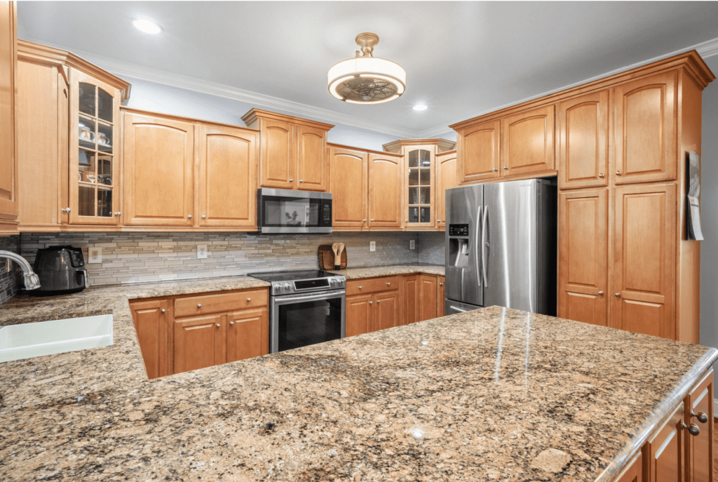 Modern kitchen with wooden cabinets and granite countertops.