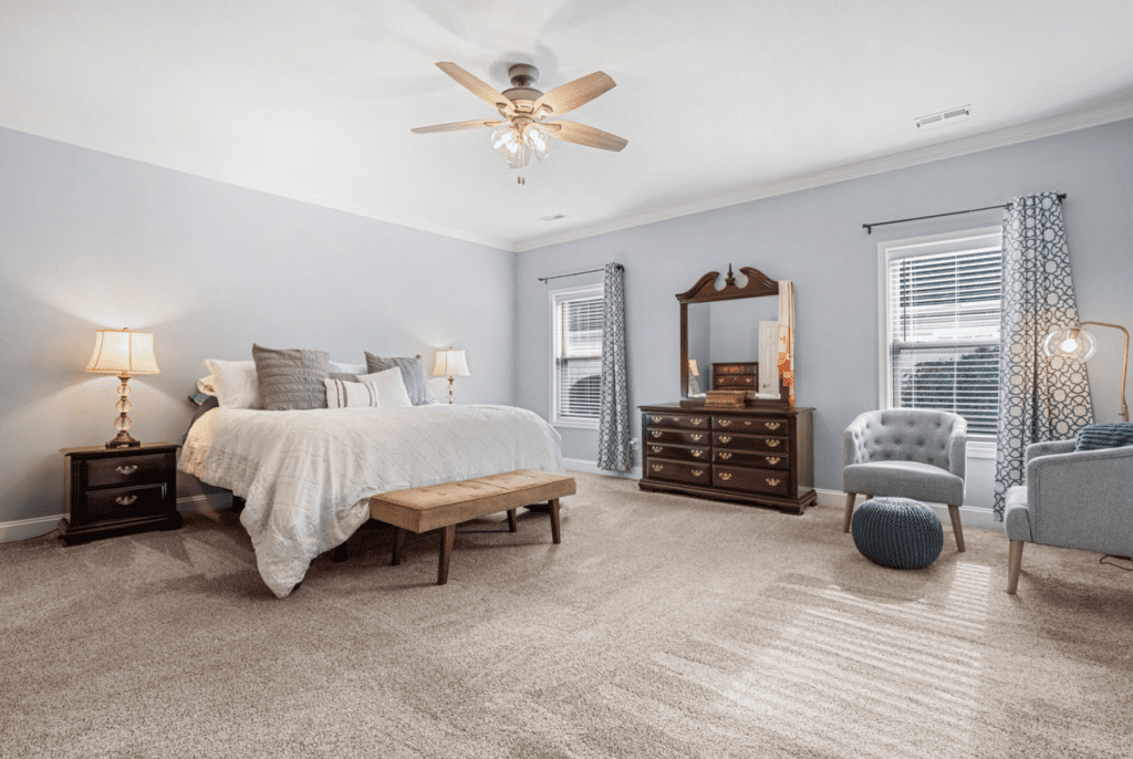Bright, spacious bedroom with neutral tones and classic wooden furniture.