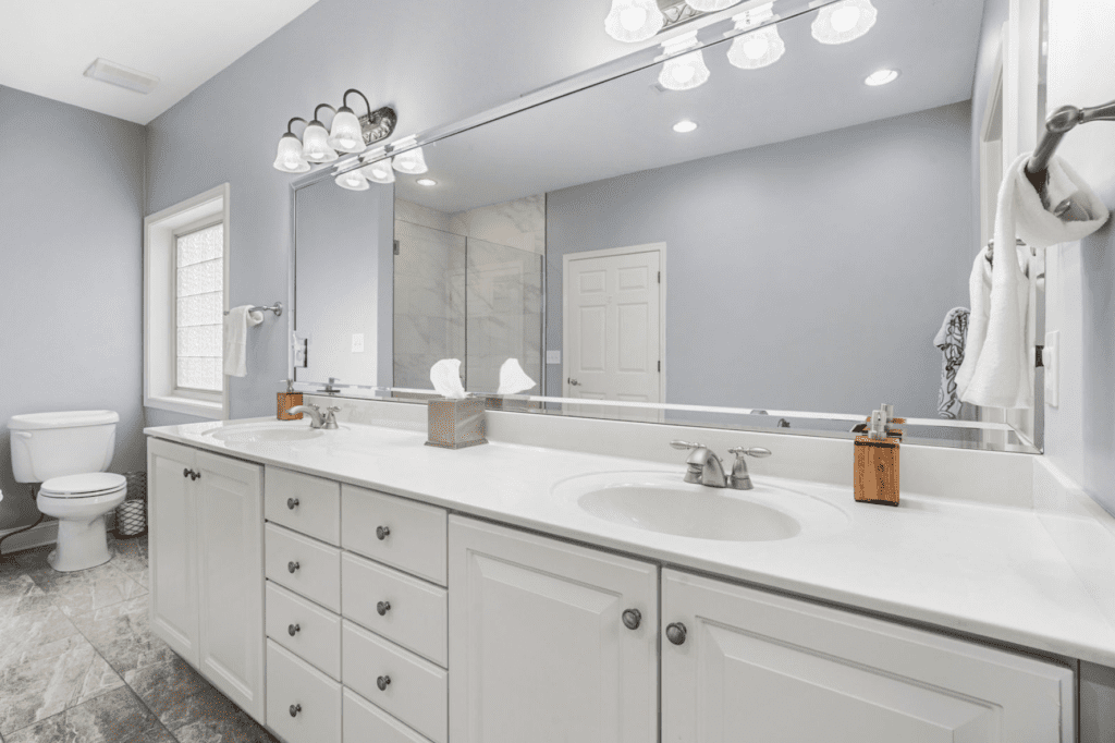 Modern bathroom with double sinks and large mirror.
