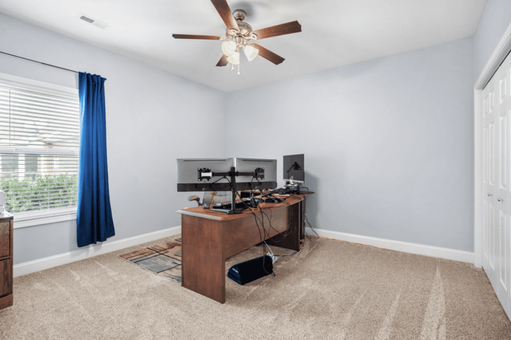 Minimalist home office with two monitors and wooden desk.