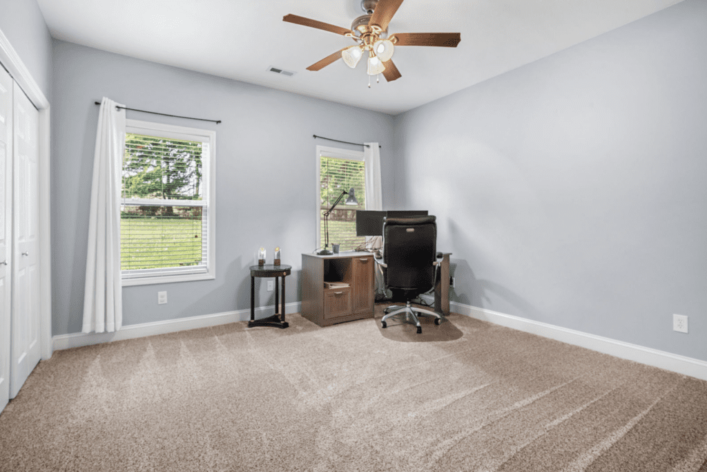 Minimalist home office with a desk, computer, and chair.