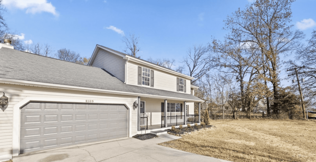 Two-story house with a front porch and attached garage.