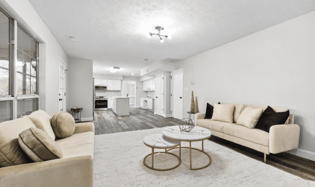 Bright, modern living room with beige sofas and round coffee tables.