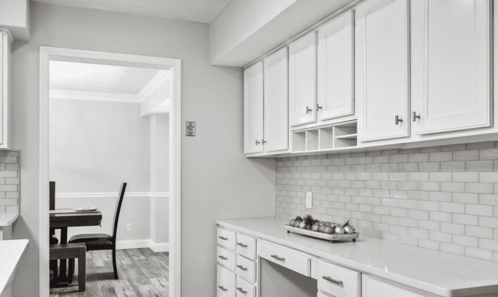 Bright kitchen with white cabinets and subway tile backsplash.