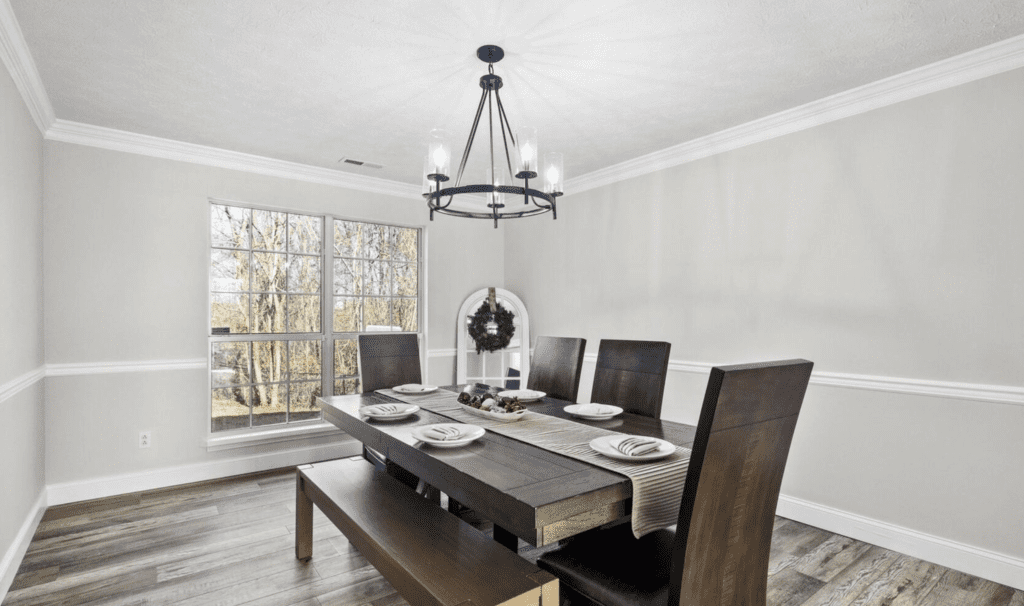 Modern dining room with dark wood table and chandelier.