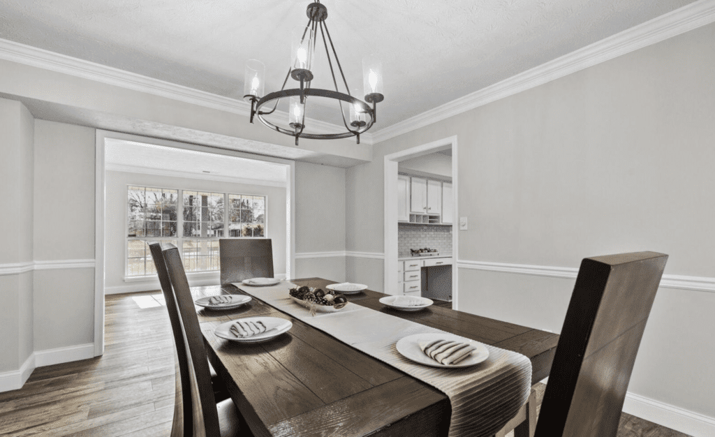 Elegant dining room with a wooden table and chandelier.