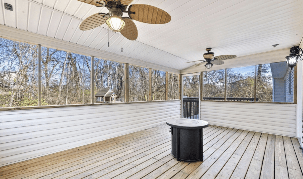 Spacious screened porch with ceiling fans and a fire pit table.