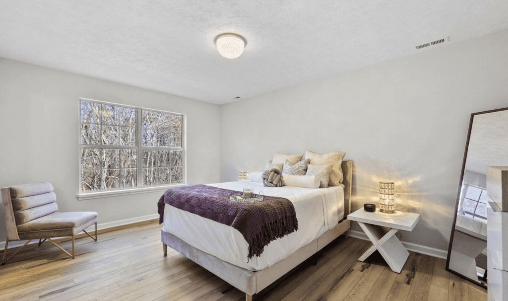 Cozy bedroom with a neatly made bed and natural light.