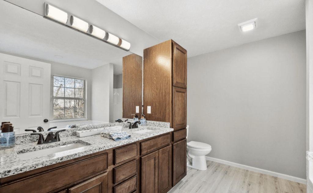 Modern bathroom with wooden cabinets and a white toilet.