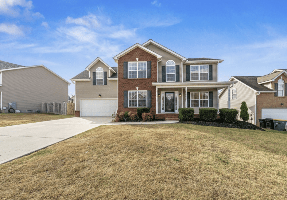 Modern two-story house with brick and siding exterior and a spacious driveway.
