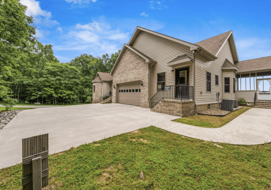 Modern suburban house with a spacious driveway and garage under a clear blue sky.